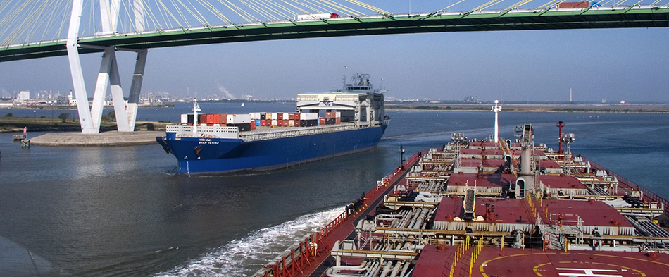 Ships transit under Fred Hartman Bridge in Houston, TX.